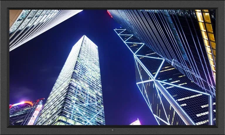 Monitor industriale Austin Hughes DP-K43 con schermo che mostra grattacieli illuminati di notte
